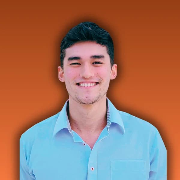 Tak Cox, smiling, in a light blue shirt